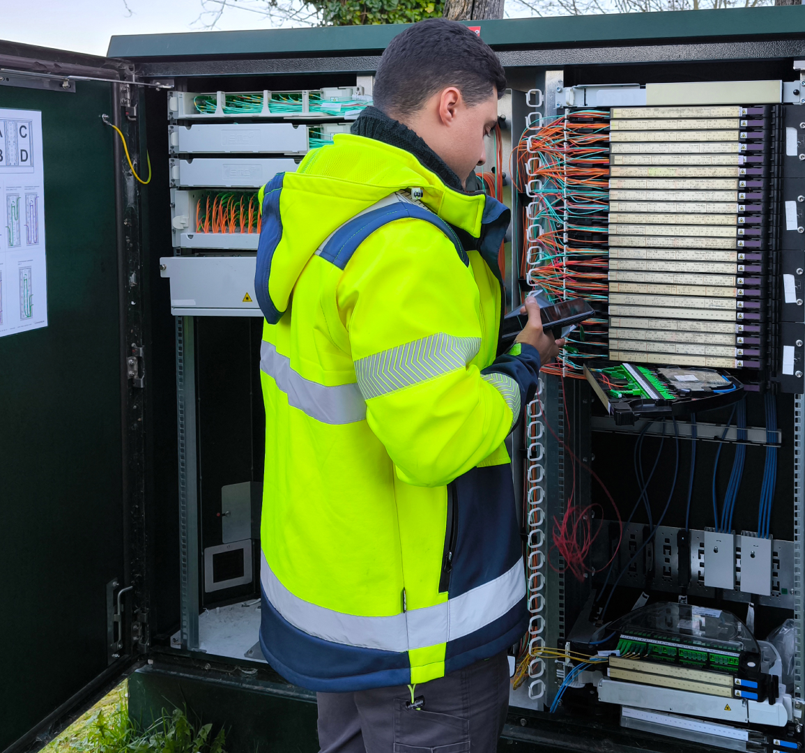 Technician inspecting outdoor electrical cabinet wiring.