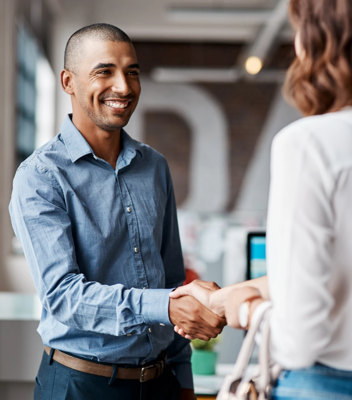 Man and woman shaking hands in office.