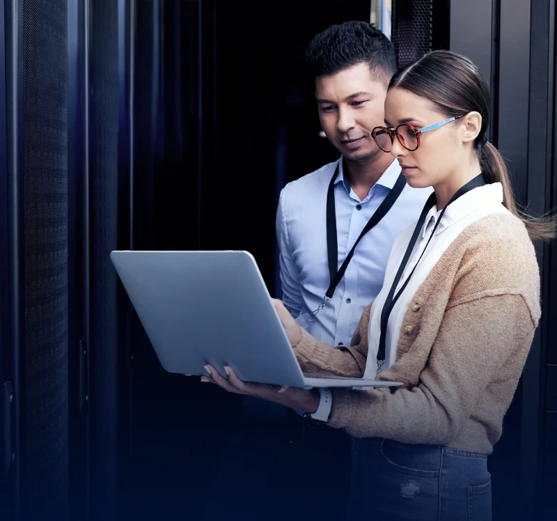 Two people working with a laptop server.