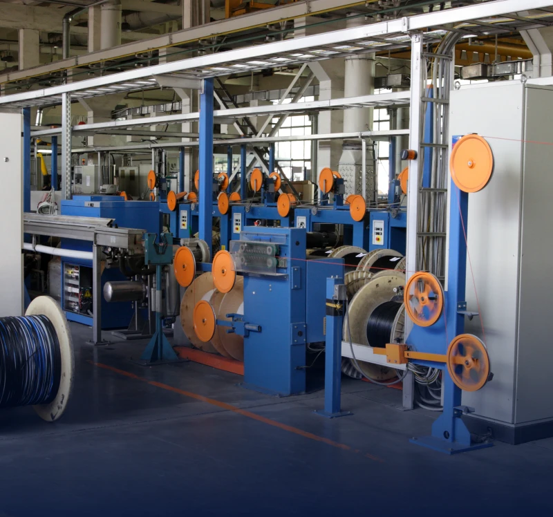 Factory machinery with orange spool wheels.