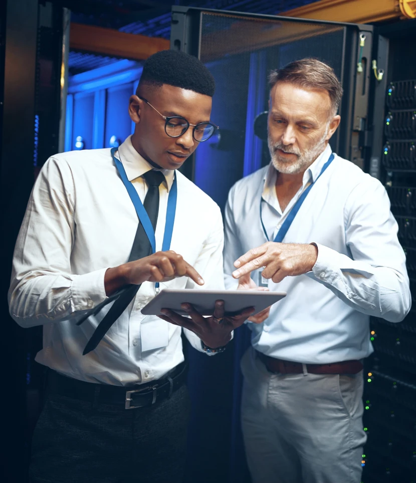 Two professionals discussing data on tablet.