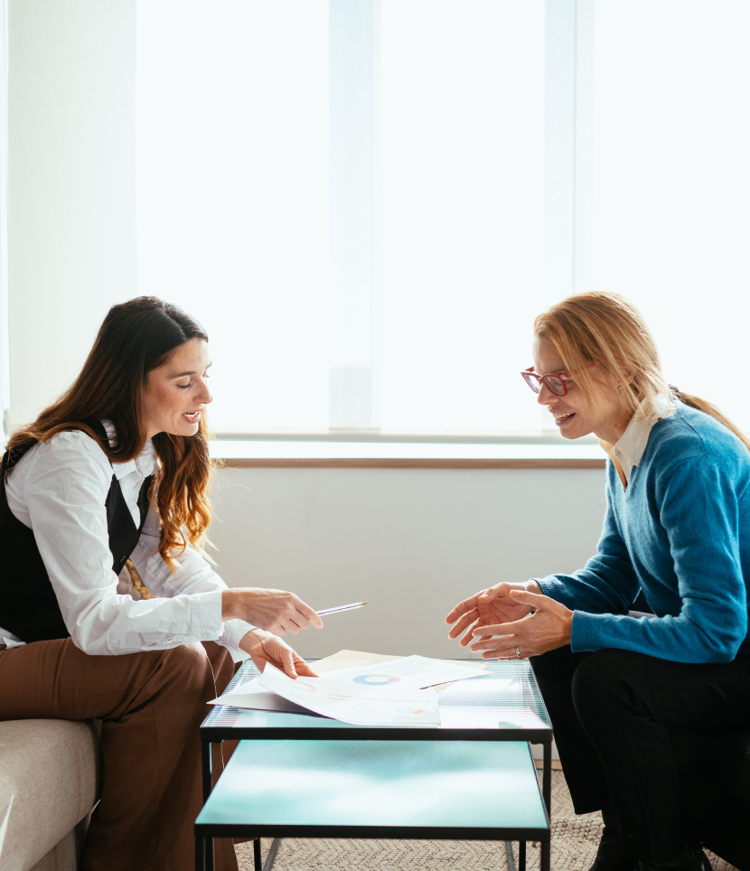 Two women discussing documents at a table.