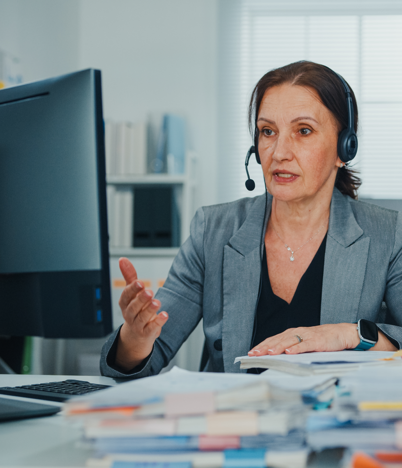 Woman in office using headset during video call.